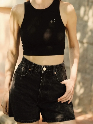 Woman wearing minimalist modern outftt with silver brooch with circle and stone