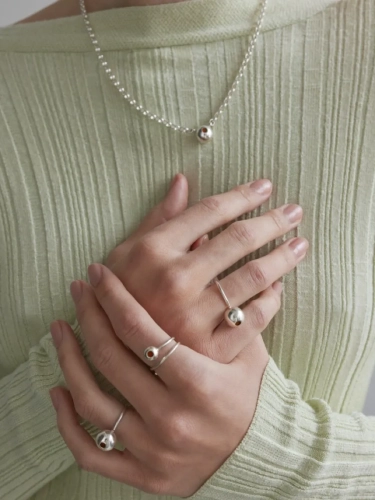 Silver chain necklace with amber sphere worn by a woman