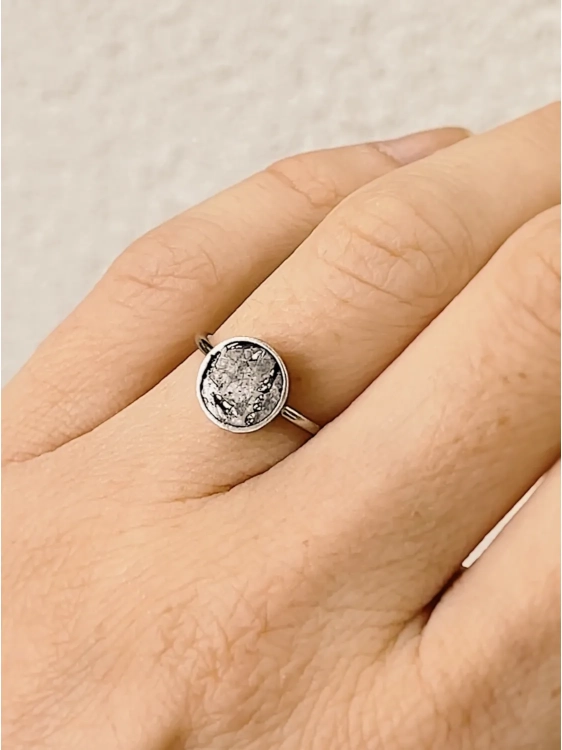 Sterling silver meteorite ring worn on hand, modern unisex jewelry with cosmic origin