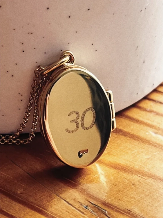 Gold locket necklace with amber and engraved back