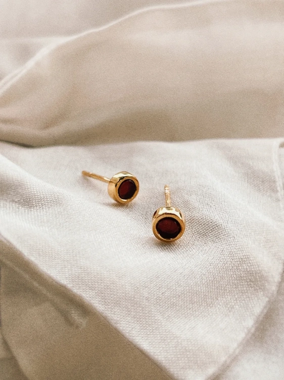 Gold stud earrings with natural Baltic amber, close-up detail